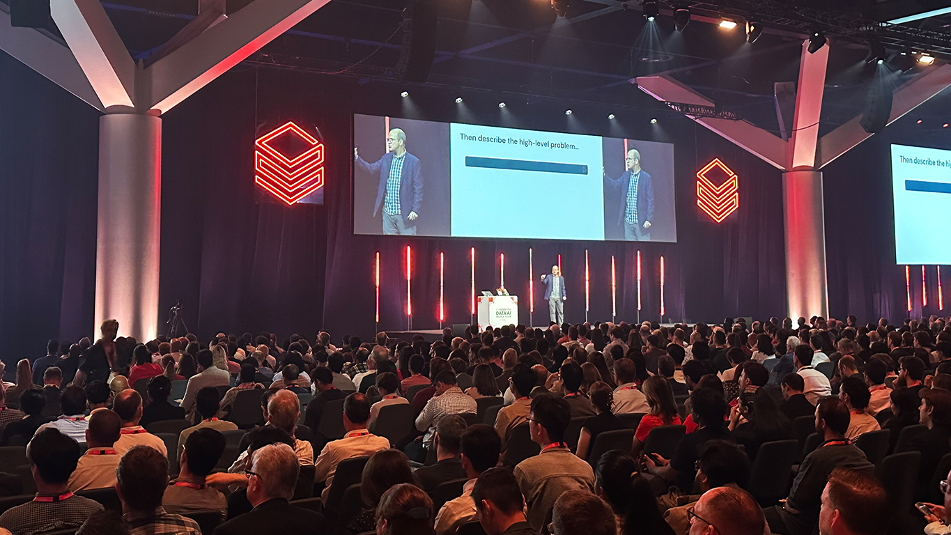 A speaker presenting on stage at Databricks Data+ AI World Tour Sydney 2025